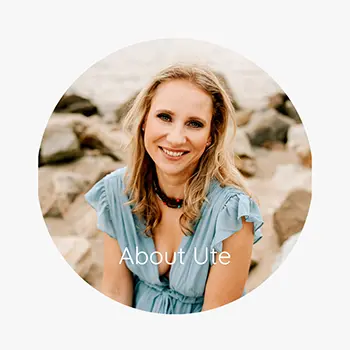 A smiling woman with long blonde hair in a light blue dress sits on rocks outdoors. The text About Ute is written at the bottom of the circular image. Photo showcasing Ute-Christin Cowan a Connecticut newborn, family and maternity photographer.