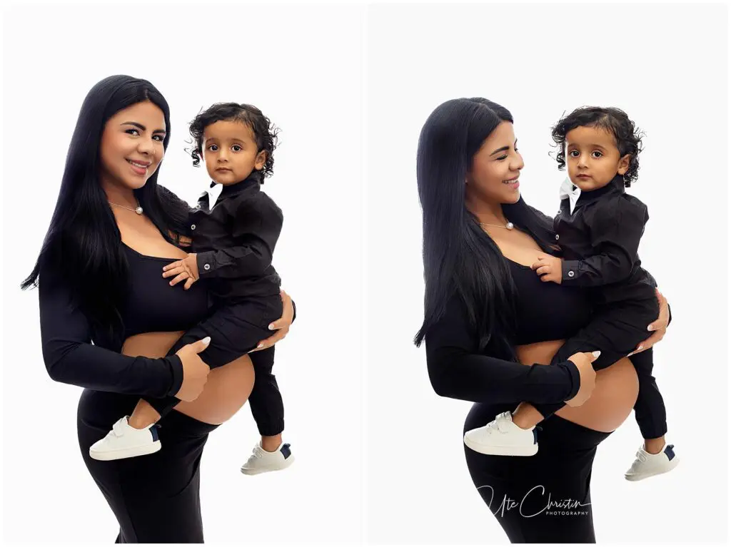 A woman with long dark hair holds a young child dressed in black. Both are smiling slightly and facing the camera in one pose and looking at each other in the other. The background is bright white.
