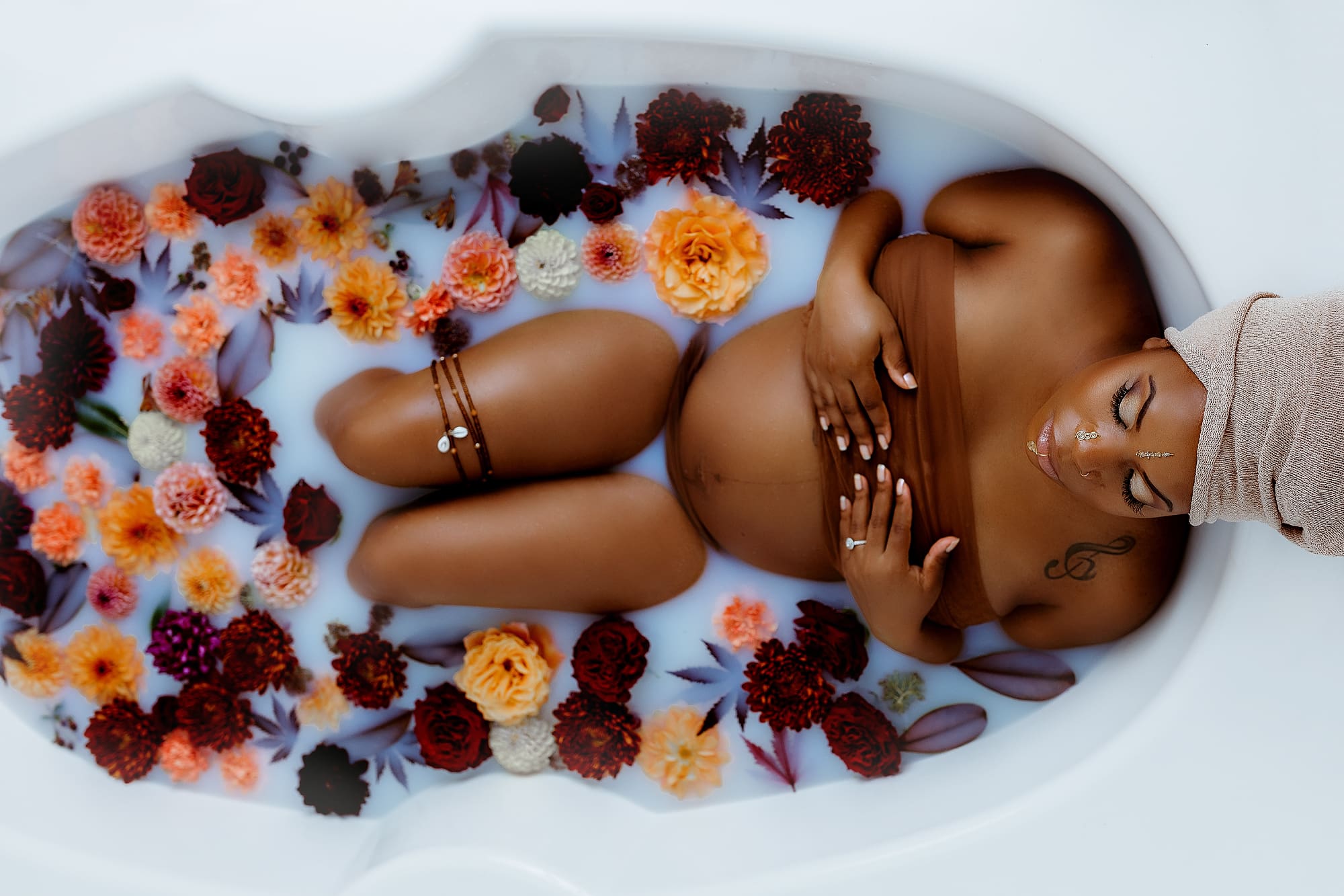 beautiful pregnant mama in a milkbath surrounded by flowers