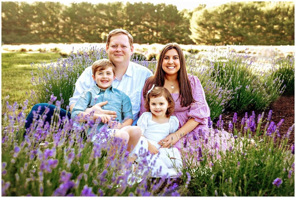 Family sitting in a lavender field to be photographed for their family portraits in CT