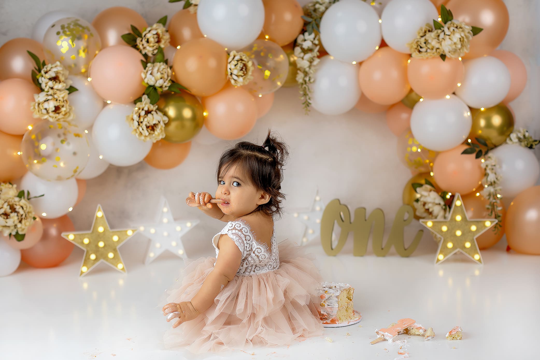 girl smashing her cake in a cute gold setup