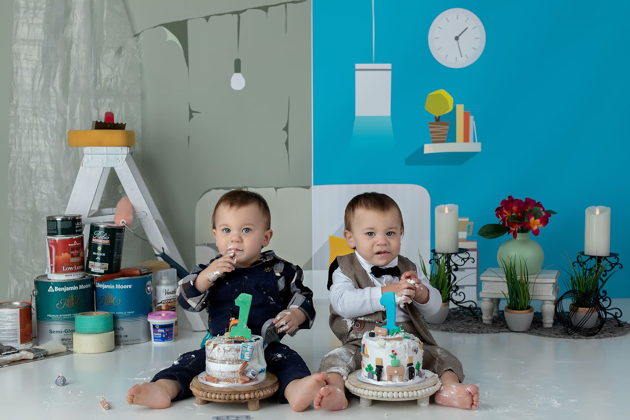 Two toddlers sit on the floor with individual cakes, wearing messy clothes. The background is split: one half looks like a room under construction, the other is bright and decorated. Both children have a “1” candle on their cakes.