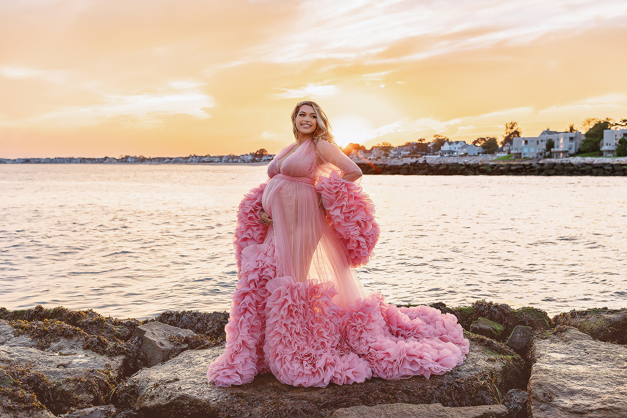 Beautiful Lady standing on a rock in a beautiful maternity gown